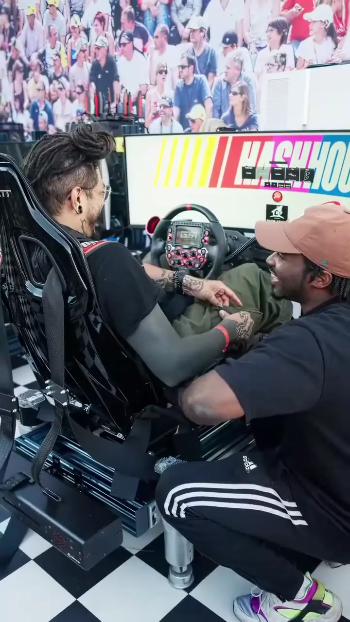 A guest at the wheel of a Trackside full-motion simulator at Puffco’s PuffCon block party