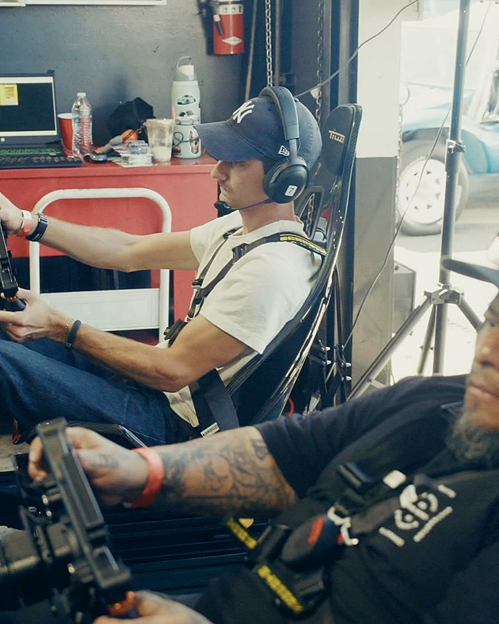 Drivers mid-race as a spectator films the action at the Pit Stop at Performance Plus fundraiser