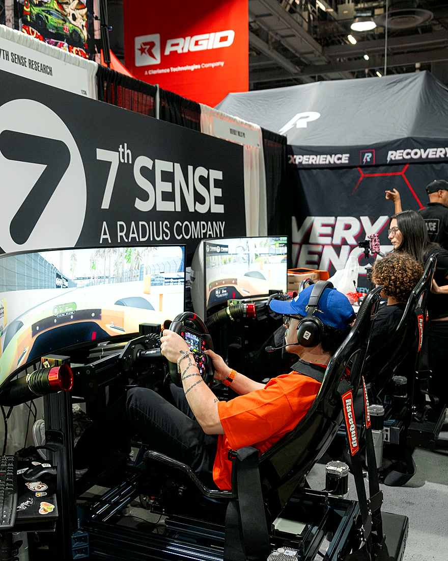 A driver racing inside the 7th Sense Research branded booth at the Long Beach Grand Prix expo