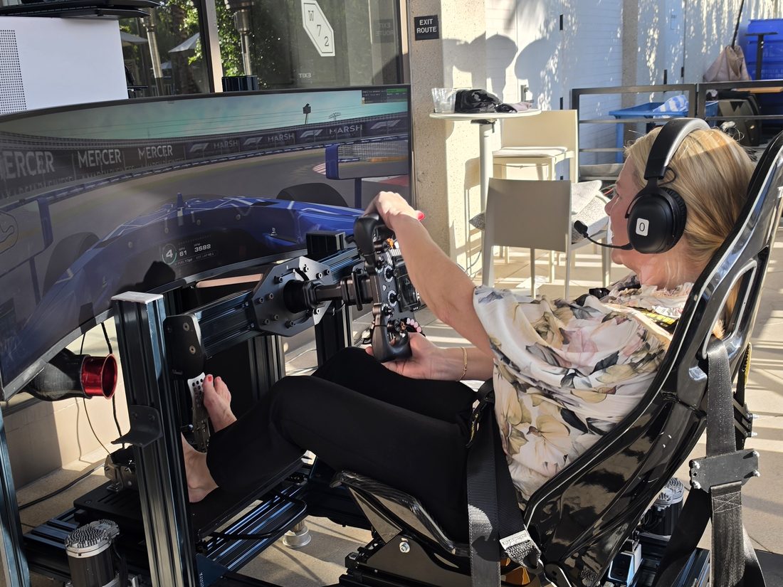 A guest at the wheel of a full-motion racing simulator at the Mercer reception in Irvine