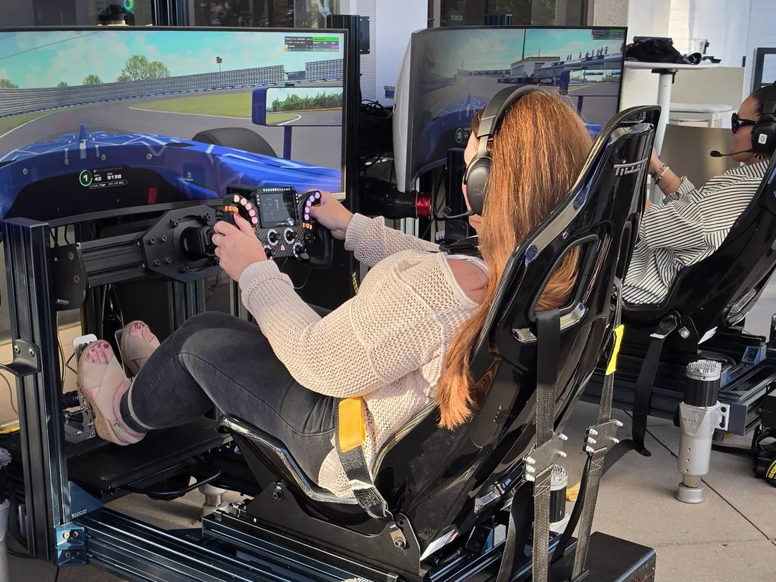 Two guests racing side by side on full-motion simulators during the Mercer Formula 4 time trial