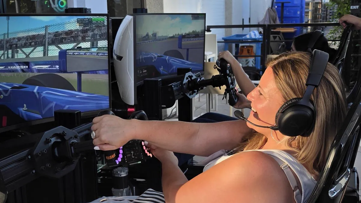 A first-time driver mid-session on a full-motion racing simulator at the Mercer reception