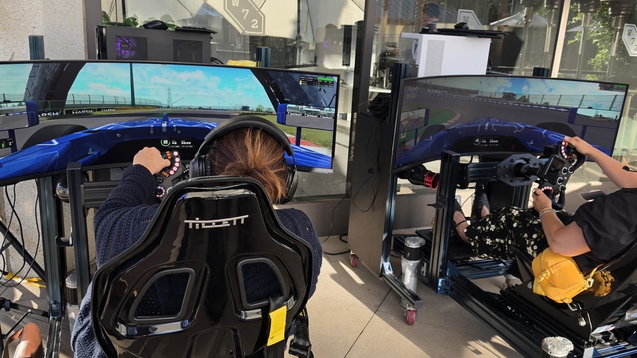 Two guests driving full-motion racing simulators side by side at the Mercer reception in Irvine, California