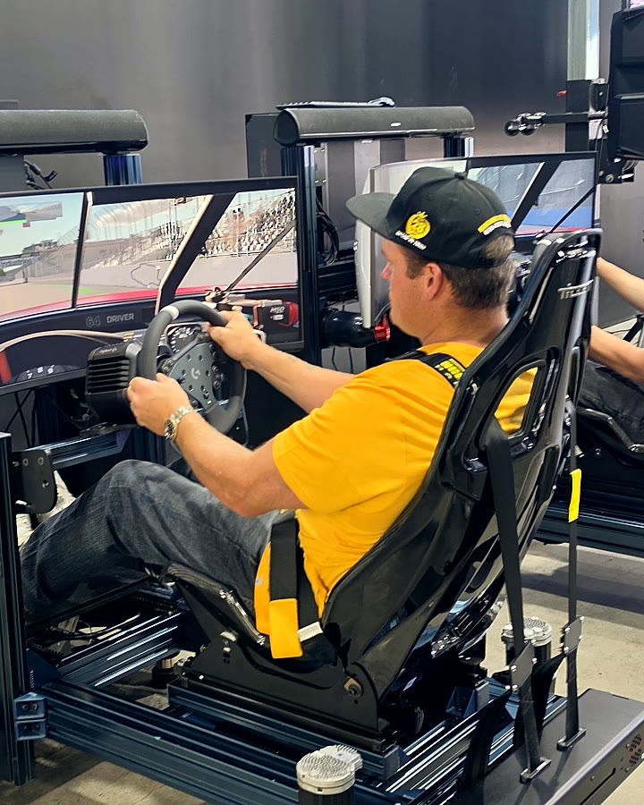 A NASCAR fan at the wheel of a full-motion racing simulator