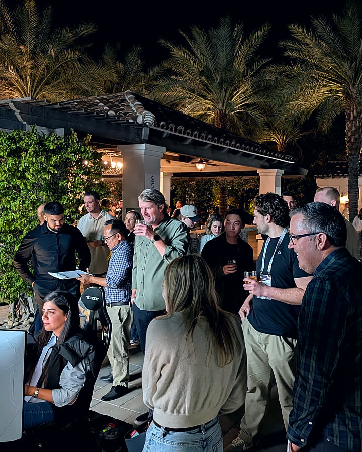 An upscale poolside evening event with guests gathered around a Trackside simulator