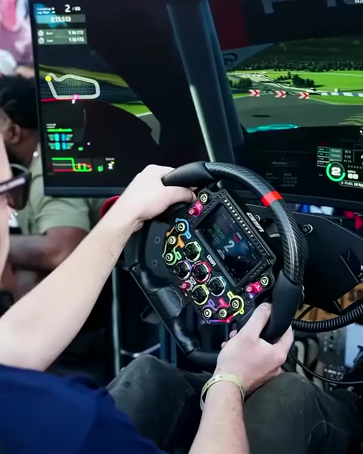 A guest at the wheel of a Trackside full-motion simulator at Puffco’s PuffCon block party